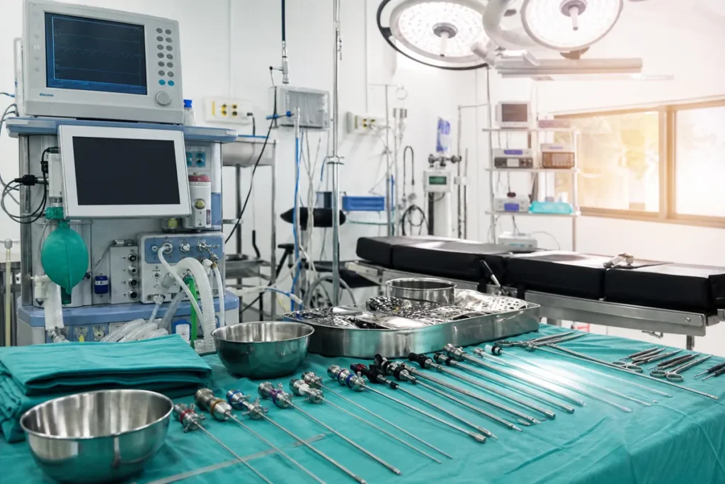 Medical equipment and surgical tools arranged in a modern Kenyan operating theatre, featuring anaesthesia monitors, liposuction cannulas, and protective gowns under bright clinical lighting.